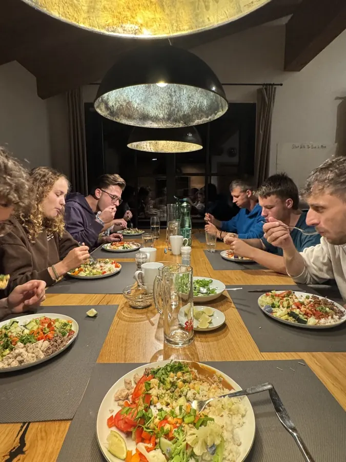 Teilnehmer beim gemeinsamen Abendessen am langen Tisch